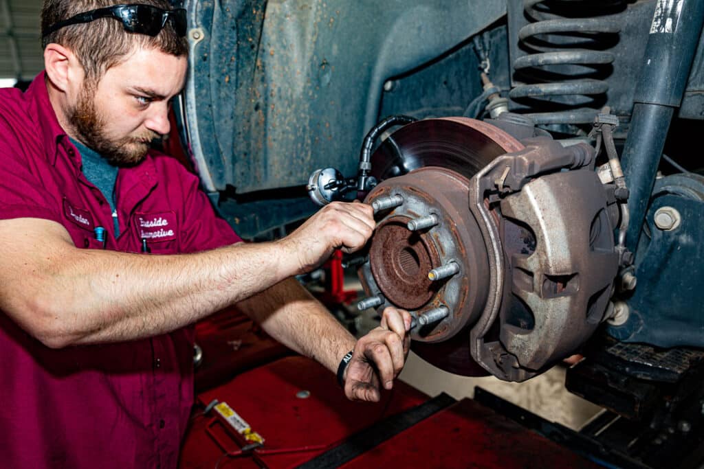 A close up photo of Expert Eastside Automotive technician performing brake repair on a vehicle in Greer, SC