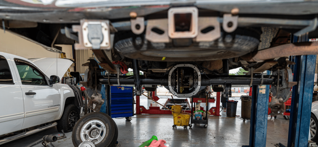 Transmission shops near me in Greer SC with Eastside Automotive. Closeup image of a truck on lift in the shop with transmission repair being done.