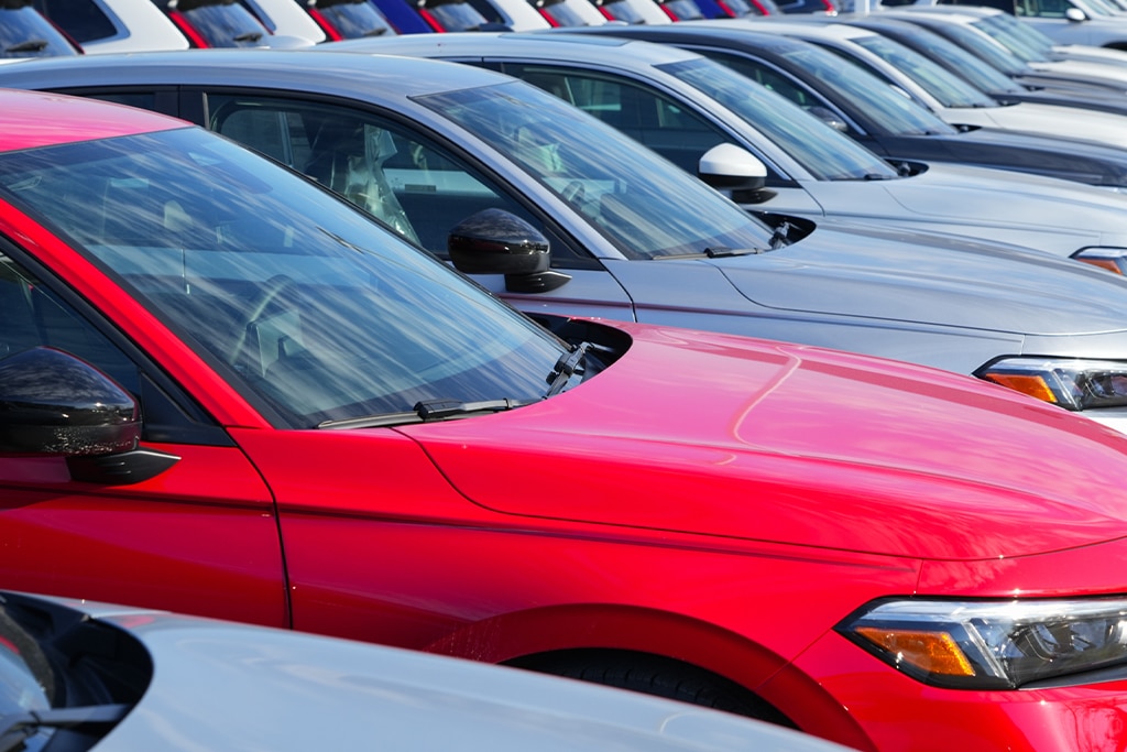 Buying a used car in Greer, SC? Pre purchase inspections at Eastside Automotive. Image of a number of red and silver used cars lined up in rows on a car sales lot.