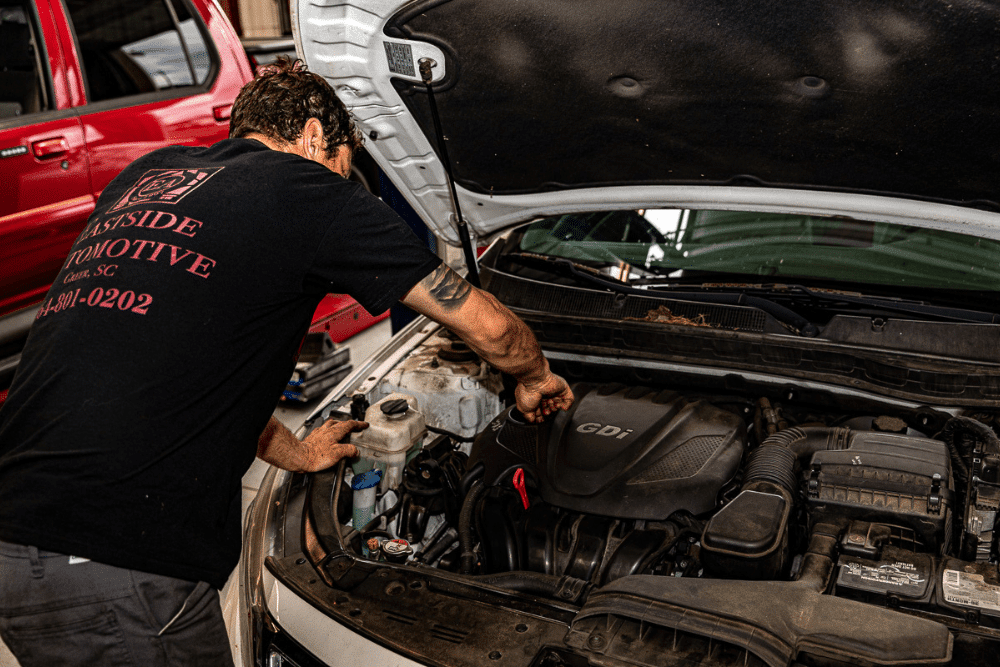 ASE-Certified Mechanics, auto repair in Greer, SC at Eastside Automotive. A mechanic at Eastside Automotive in Greer, SC, inspecting a vehicle engine under the hood for maintenance and repair.