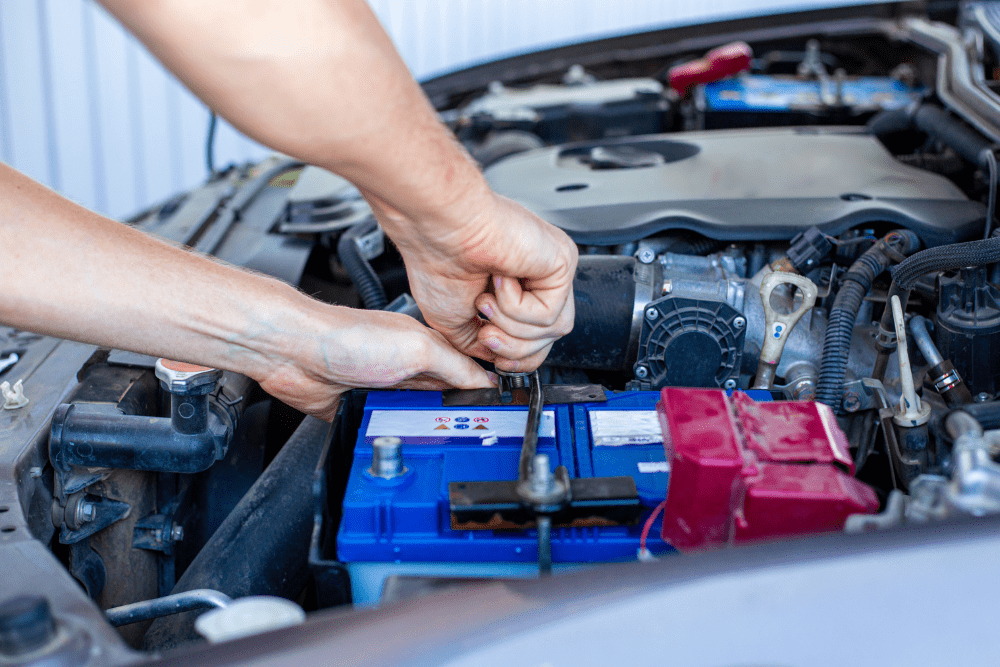Car won't start, auto repair in Greer, SC by Eastside Automotive. Image of a technician securing a car battery under the hood, highlighting the shop’s commitment to reliable starting power and safe electrical performance.
