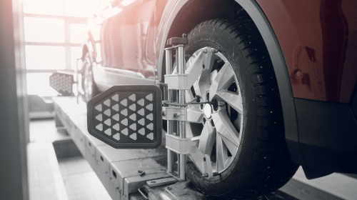 wheel alignment service, auto repair in Greer, SC at Eastside Automotive. Image shows a vehicle on a lift with alignment sensors attached.